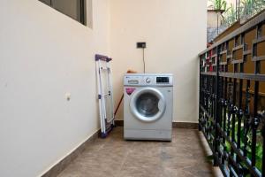 a washing machine in a room with wine bottles at Najjera Apartments in Kira
