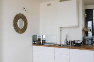 布洛涅-比扬古Superb apartment with view of Eiffel Tower的厨房配有白色橱柜和墙上的镜子