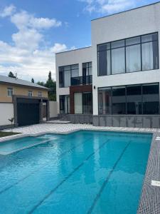 a swimming pool in front of a house at Комфорт Вилла in Yusufkhona +11 photos