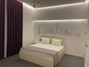 a white bedroom with a bed with a wall at Комфорт Вилла in Yusufkhona