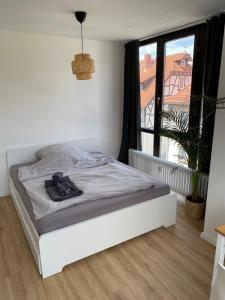 ein weißes Bett in einem Zimmer mit Fenster in der Unterkunft Apartment zentral in Gießen mit Balkon! in Gießen