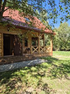 a house with a wooden porch with a fence at Domek Pod Siodłem in Wetlina