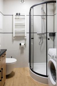 a bathroom with a shower and a toilet and a sink at Sekwoja Rent - Malmeda 15 in Białystok +27 photos