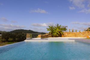 a large swimming pool next to a brick wall at Quinta da Murnalha in Azueira