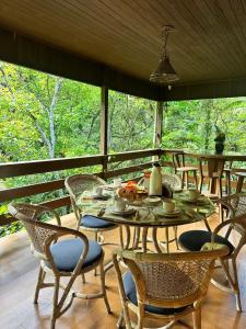 a patio with a table and chairs on a porch at Casa de campo com cachoeira no quintal in Gaspar
