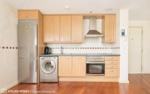 サビニャニゴにあるLas Margas Vistas Golfのキッチン(木製キャビネット、洗濯機付)