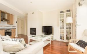 サビニャニゴにあるLas Margas Vistas Golfのリビングルーム(白い家具、テレビ付)