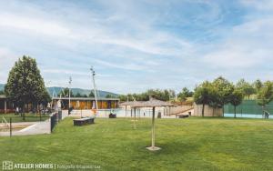 サビニャニゴにあるLas Margas Vistas Golfの芝生の傘と遊び場のある公園