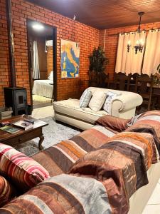 a living room with two couches and a mirror at Casa de campo com cachoeira no quintal in Gaspar