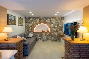 un salon avec un canapé et un mur en pierre dans l'établissement Apartment Srica, à Kraljevica