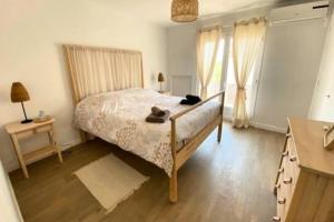 a bedroom with a bed and a table and a window at Spacious house with balcony in Sainte-Maxime