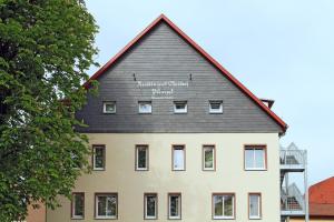 uma casa grande com um telhado preto em GROSCH Brauhotel & Gasthof em Rödental