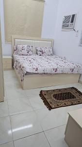 a bedroom with a bed and a rug on the floor at Welcome One 5km far from Masjid Nabawi in Al Madinah