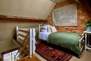 a bedroom with a bed and a brick wall at Old country cottage in Ashbourne