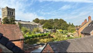 a view of a city with a church and roofs at Old country cottage in Ashbourne