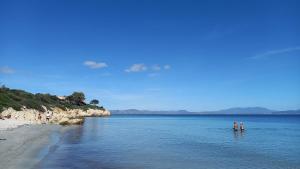 two people standing in the water on a beach at Affittacamere Casa Chiara in SantʼAntìoco