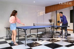 a man and a woman playing a game on a ping pong table at EKOSTAY - Hazelnut Villa in Alibaug