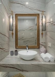 ein Badezimmer mit einem weißen Waschbecken und einem Spiegel in der Unterkunft Prime City Residence by Sweet Home in Yerevan