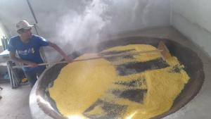 una persona cocinando comida en una sartén con un palo en Camping em Castanhal para COP 30, en Castanhal