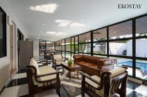 a living room with a couch and chairs and a pool at EKOSTAY - Hazelnut Villa in Alibaug