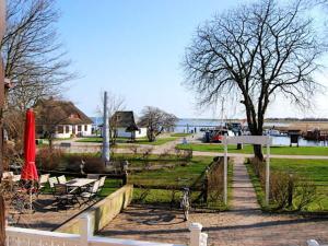 a park with benches and a table and an umbrella at Hotel Hiddensee Hitthim in Kloster