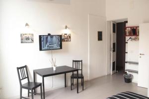 una sala da pranzo con tavolo, sedie e TV di DownTown art in Town a Catania