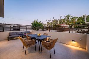 a patio with a table and chairs on a balcony at Beach Luxury Homes - Zoe in Lampi