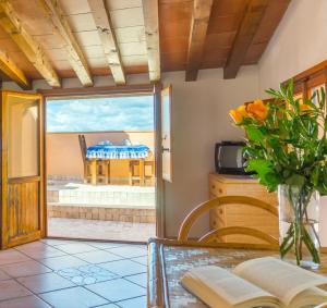 a room with a table with a vase of flowers at Cota Quinta in Rio nellʼElba