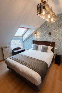 モンマローにあるLogis Hôtel Centrotel et Spa Bulles d'Allierの大きなベッドと窓のある寝室 +33枚の写真