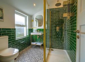 a green tiled bathroom with a toilet and a shower at Ramsgate Family Cottage nr Beach -Harbour- Sleeps 4 - Garden - Parking on Street in Ramsgate