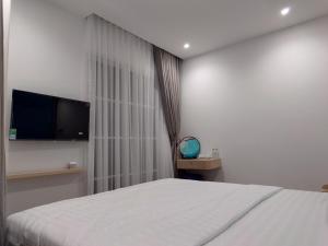 a bedroom with a bed and a flat screen tv at Sun Bay Hotel Phu Quoc in Phu Quoc