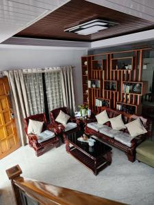 een woonkamer met twee banken en een tafel bij Goldland Caelestis Guest House in Bacolod