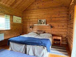 a bedroom with a bed in a log cabin at The Pintorp cabin by the lake in Mora +35 photos
