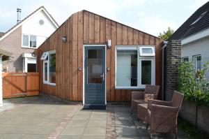a wooden house with a door and two chairs at Eindhoven 2 Sleep in Eindhoven