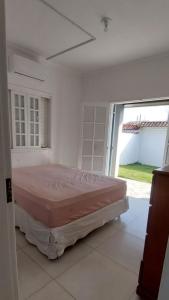 une chambre avec un lit dans une pièce avec une fenêtre dans l'établissement Casa de Praia em Bertioga, São Paulocom Piscina Ar Condicionado Wifi a 500m do Mar, à Bertioga