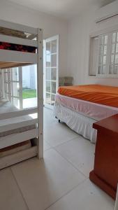 une chambre avec deux lits superposés et une fenêtre dans l'établissement Casa de Praia em Bertioga, São Paulocom Piscina Ar Condicionado Wifi a 500m do Mar, à Bertioga 8 autres photos