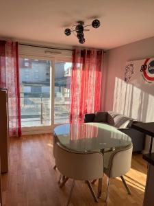 Una sala de estar con una mesa de cristal y un sofá. en Appartement proche mer, en Bray-Dunes