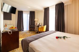 a hotel room with a bed with flowers on it at Hotel Brilliant Plaza in Zalău