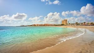 plaża z turkusową wodą i budynkami w tle w obiekcie Casitas Tenerife - El Risco 2 w mieście Los Cristianos