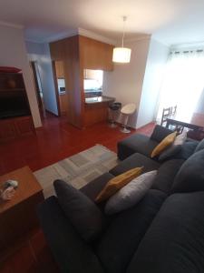 a living room with a blue couch with pillows at Village Sea House - Porto Moniz in Porto Moniz