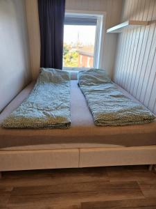 een bed in een kamer met een raam bij Heges place in Sandefjord