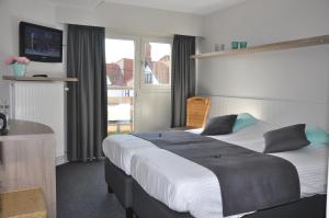 une chambre d'hôtel avec un grand lit et une fenêtre dans l'établissement Hotel Bilderdijk, au Coq