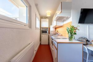 eine kleine Küche mit einer Theke und einem Fenster in der Unterkunft Le Ptit Bois - Piscine partagée in Saint-Laurent-en-Grandvaux