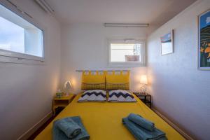 ein Schlafzimmer mit einem gelben Bett mit zwei Kissen in der Unterkunft Le Ptit Bois - Piscine partagée in Saint-Laurent-en-Grandvaux