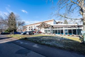 ein großes Gebäude mit auf einem Parkplatz abgestellten Autos in der Unterkunft Le Ptit Bois - Piscine partagée in Saint-Laurent-en-Grandvaux