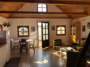a living room with a table and a kitchen at Casa da Seara in Pázmánd