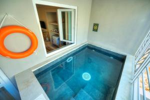 a swimming pool in a house with an orange tub at The Segond Hotel in Xagħra