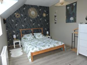 a bedroom with a bed with a floral wallpaper at chambre lit double in Tourville-la-Campagne