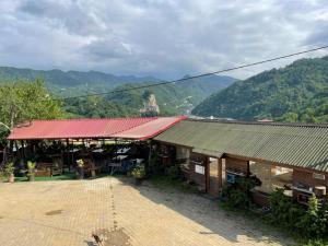 a building with a red roof with mountains in the background at HARUNAĞALAR 105 dağ manzaralı oda in Araklı +49 photos