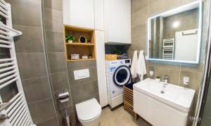 a bathroom with a sink and a washing machine at Iris Studio Apartment in Mostar